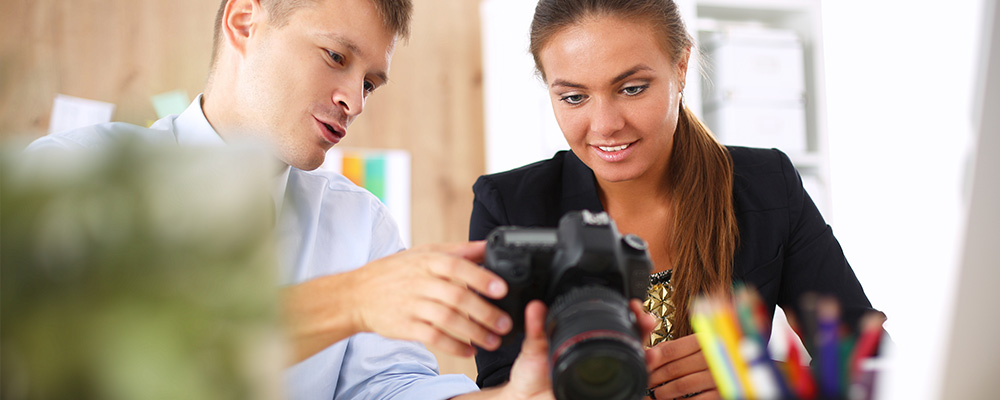 junge frau schaut bewerbungsfoto beim fotograf an